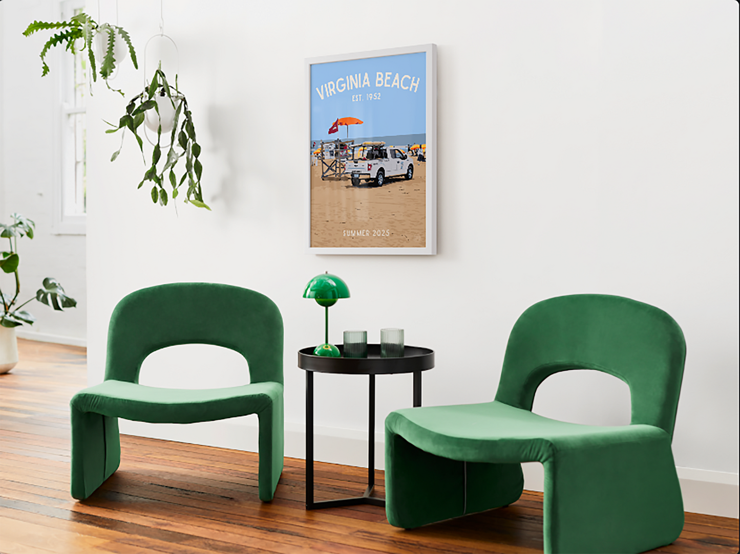 Two green chairs in a room with a framed poster of Virginia Beach on the wall.