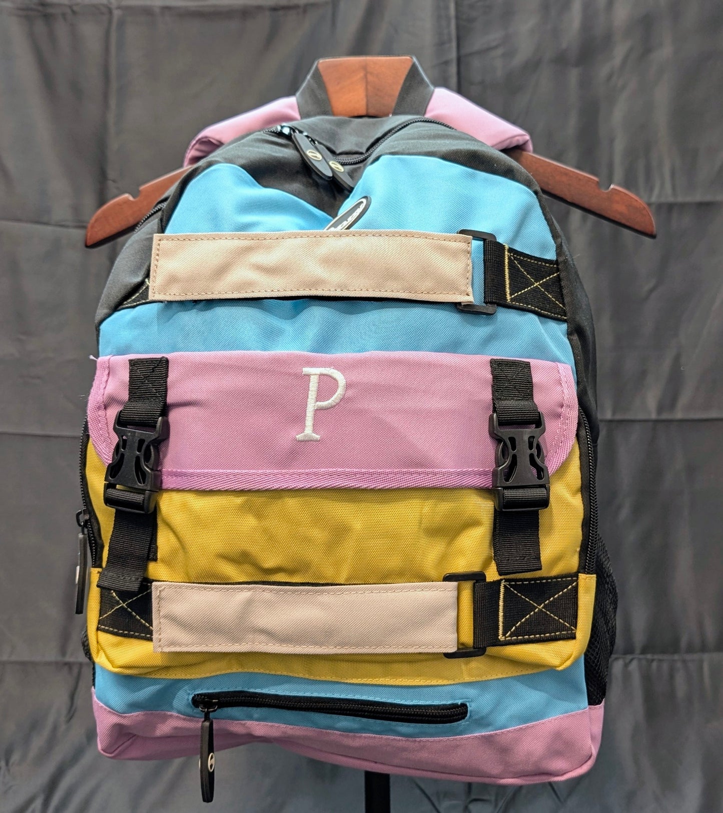 Colorful backpack with a 'P' logo on a gray background