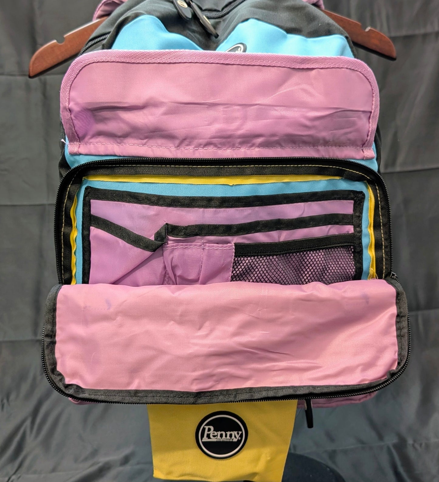 Pink and yellow travel organizer with 'Penny' branding on a gray background