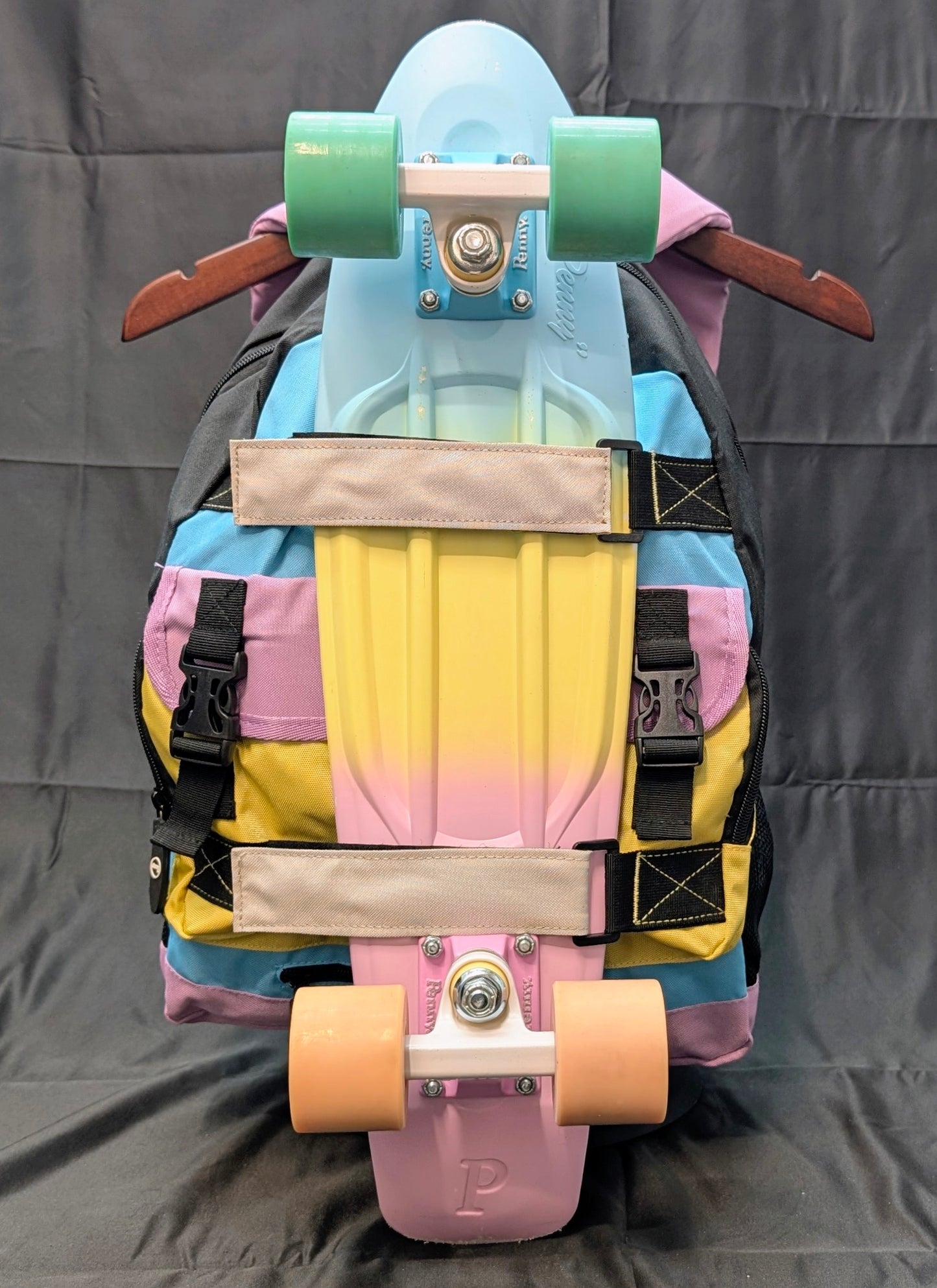 Colorful skateboard with a backpack on a gray background
