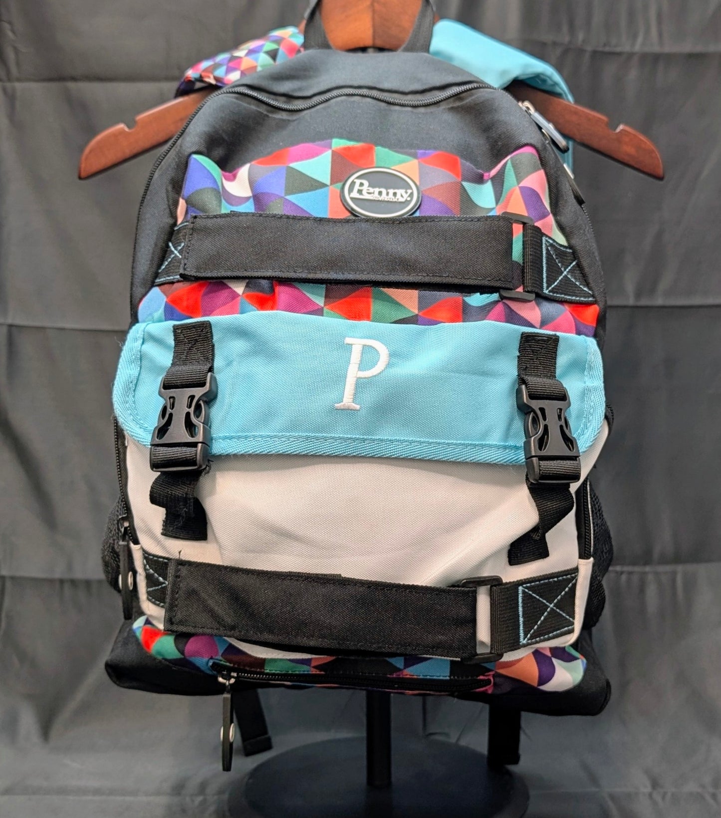 Multicolored backpack with geometric pattern on a gray background