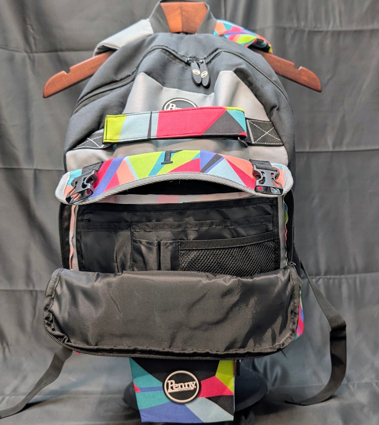Gray backpack with colorful accents on a hanger against a gray background